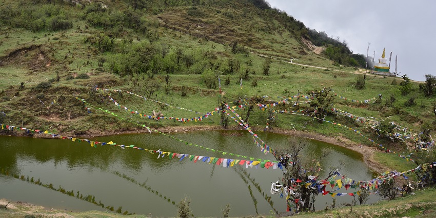 A lake at Singalila National Park with serene views and lush greenery all around.