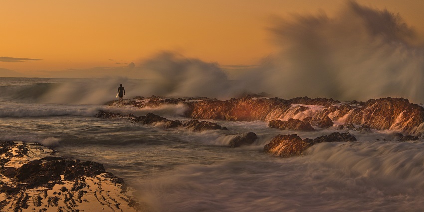 The beautiful waves spray on the Snapper Rock near Coolangatta Beach in Australia