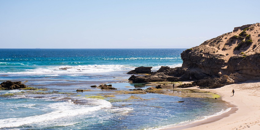 Sorrento Back Beach with rugged cliffs, rock pools, and waves.