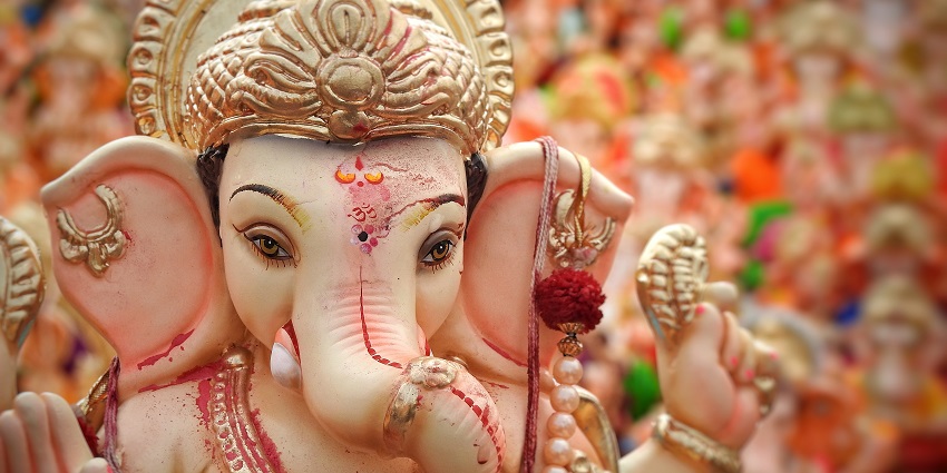 An image of lord Ganesha idol with beautiful decorations creating a temple-like structure
