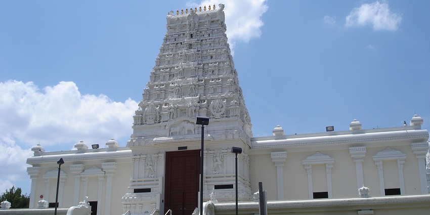 An image of a Hindu temple with a large, tall spire and intricate carvings, located in Lanham, Maryland.