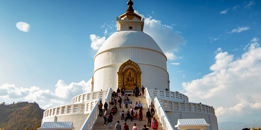 Traditional temple with ornate architecture surrounded by trees and a clear sky.