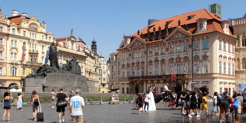 An image of a crowded Staroměstské náměstí in Prague with historical buildings.
