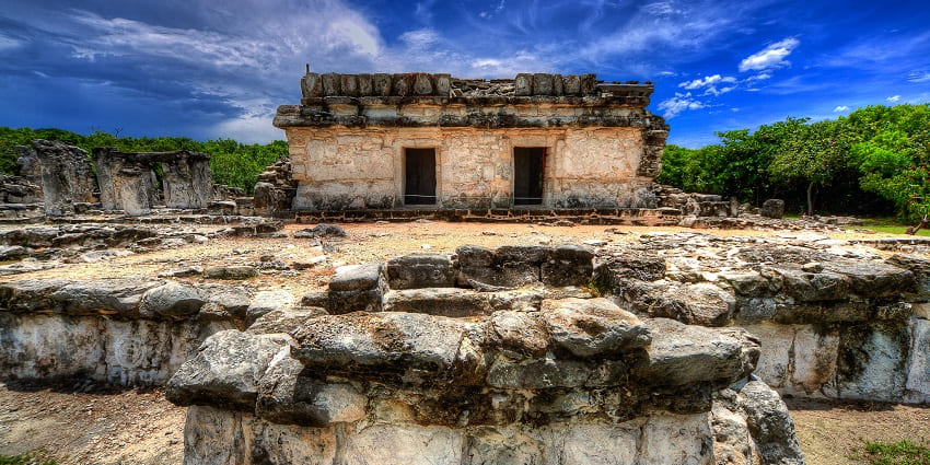 A spectacular view of a Mayan ruin surrounded by greenery in Cancun, Quintana Roo.