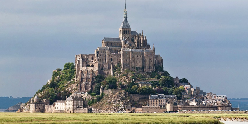 A distant view of the Mont Saint Michel along the scenic Couesnon River in Normandy, France