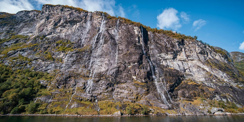 An image view of Tanda Waterfall flowing gracefully amidst lush greenery in Shahjahanpur.