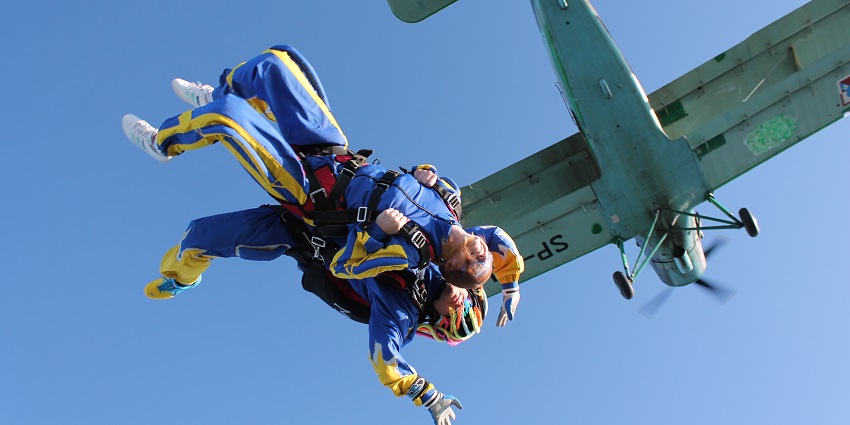 Tandem skydiver along with an individual takes a jump from the aircraft