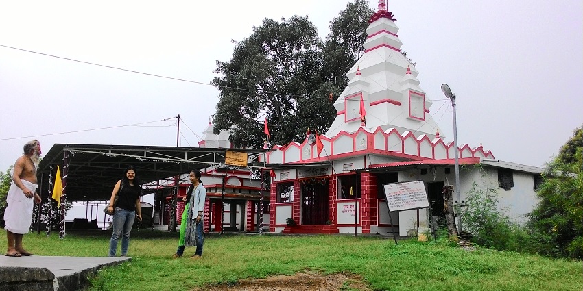 Ancient Shiva temple nestled in a cave with natural springs.