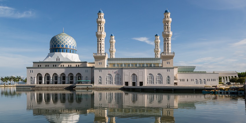 An image of a beautiful mosque along with a lake in the background.
