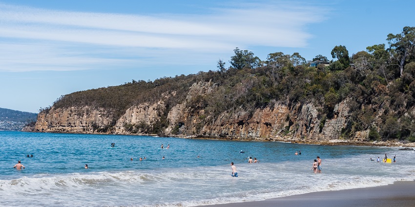 People relaxing and enjoying a swim at Taroona Beach.