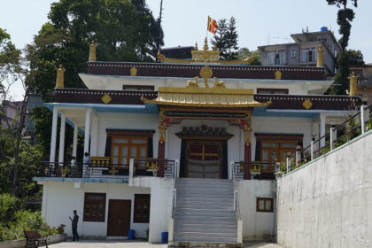 A view of Geden Tharpa Choling Monastery, featuring traditional Buddhist architecture.