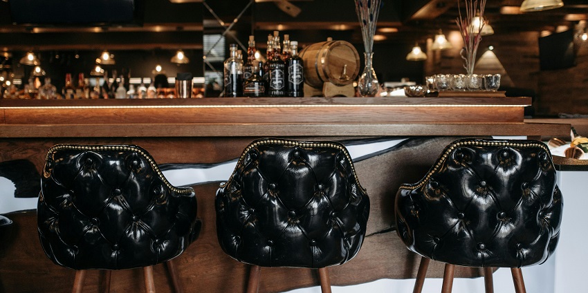 A luxury dark-themed bar with alcohol bottles on the shelves showcasing Sofia nightlife.