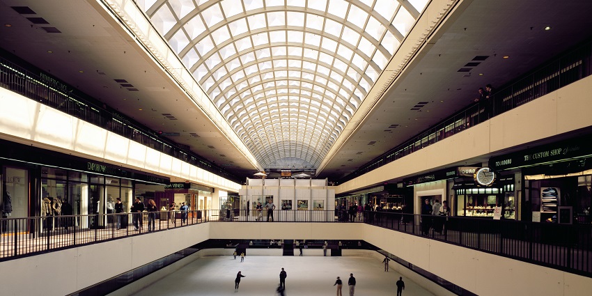 Skating rink inside the Galleria Mall with people skating and shops on the first floor