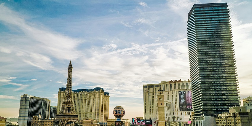 The Las Vegas strip at night with well-lit buildings, multiple casinos and people visiting