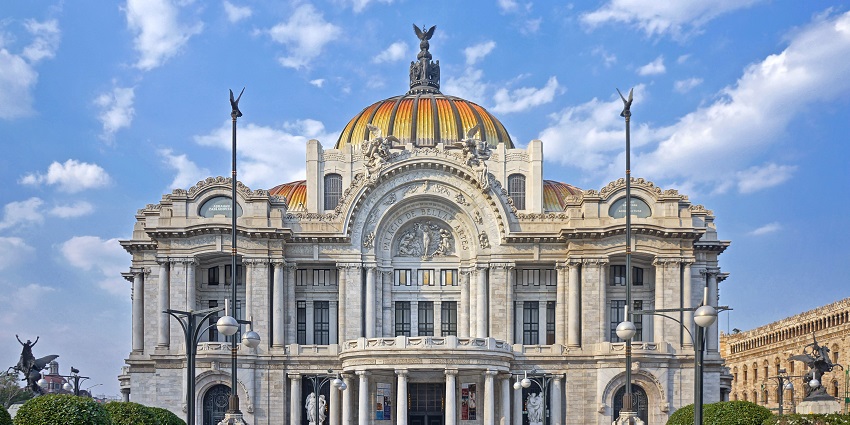 A distant outside view of the stunning Palace of Fine Arts located in Mexico City.
