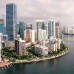 Miami Beach with a small shoreline, residential buildings and multiple boats on the sea.