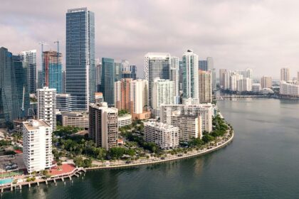 Miami Beach with a small shoreline, residential buildings and multiple boats on the sea.