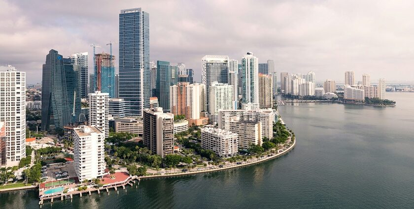 Miami Beach with a small shoreline, residential buildings and multiple boats on the sea.