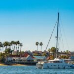 A panoramic view of a yacht near the coast with homestays in the background.