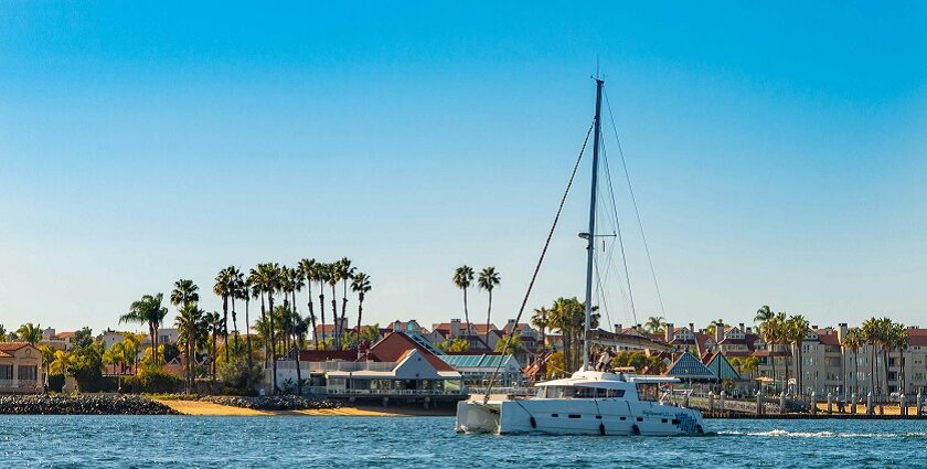 A panoramic view of a yacht near the coast with homestays in the background.