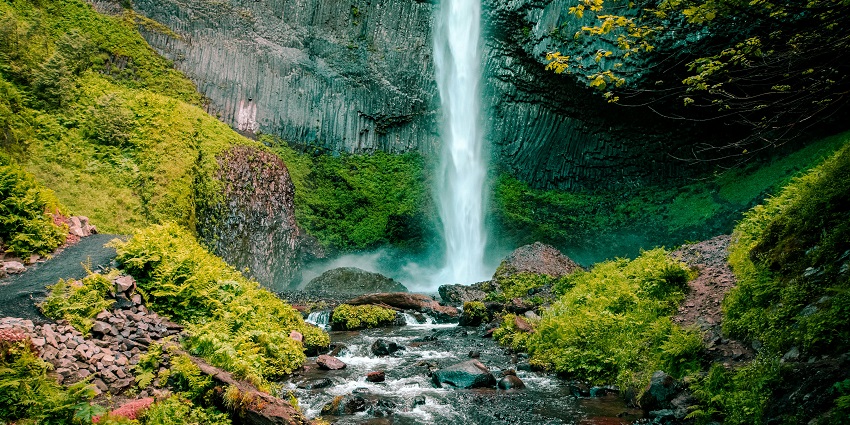 An image of majestic waterfall surrounded by lush greenery, ideal for picnics.