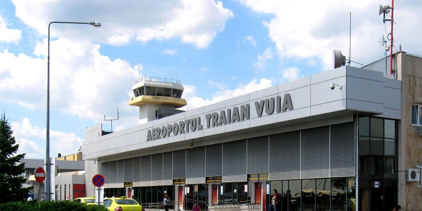 Building of Timisoara Traian Vuia International Airport with people and taxis parked