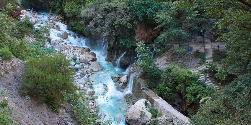 Water from waterfalls merging into the stream that is situated near the stone stairs