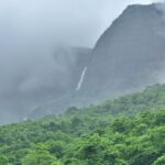 A picture of Bhandardara Trekking scenic view of Ratangad Lake surrounded by lush hills.