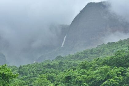 A picture of Bhandardara Trekking scenic view of Ratangad Lake surrounded by lush hills.