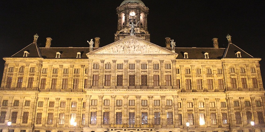 Wide-angle view of the renowned Royal Palace in Amsterdam at night.
