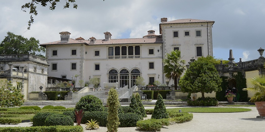 Vizcaya museum and gardens with a white building of the museum and a small water body.