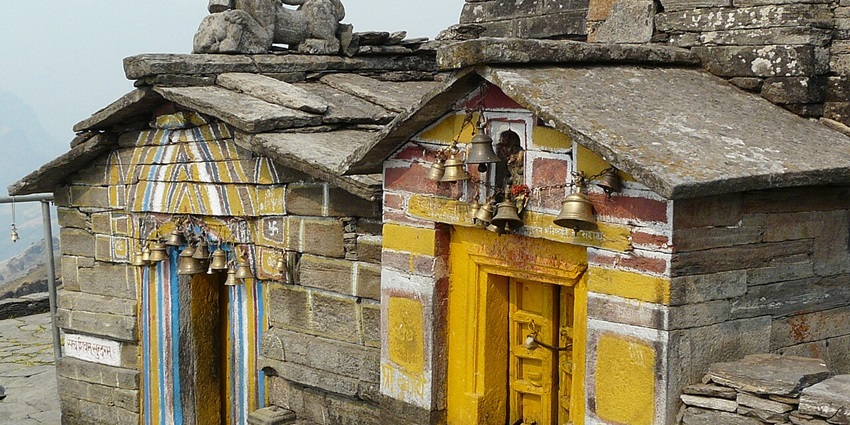 A picture of a historical temple surrounded by lush Himalayan peaks near Ardhnarishwar Temple