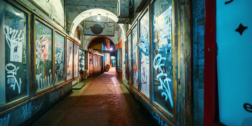 Colourful underground tunnel complex with tags and posters on the wall with graffiti