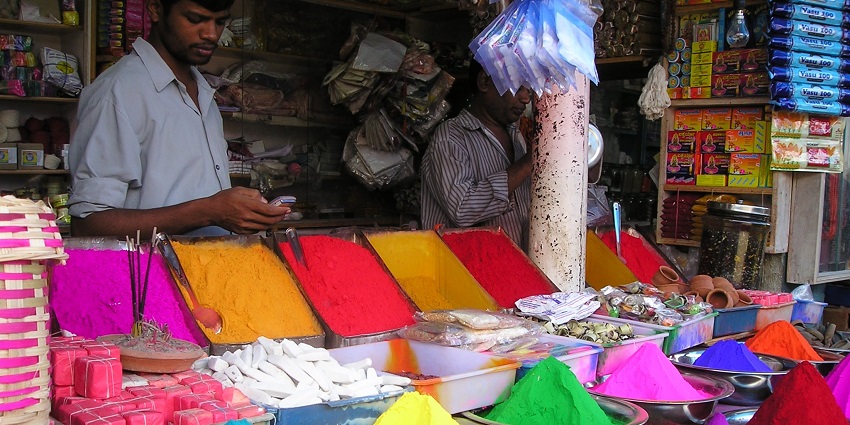 Busy street market featuring clothes, accessories, and eateries.