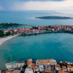 Seaside town in Bulgaria with small islands in the distance and small buildings