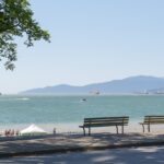 A scenic view of English Bay in Vancouver, featuring calm waters and a vibrant coastline.