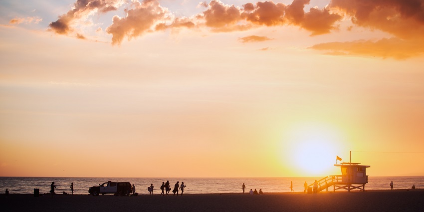 Sunset on the Venice Beach Boardwalk with pink sky across the horizon in Los Angeles