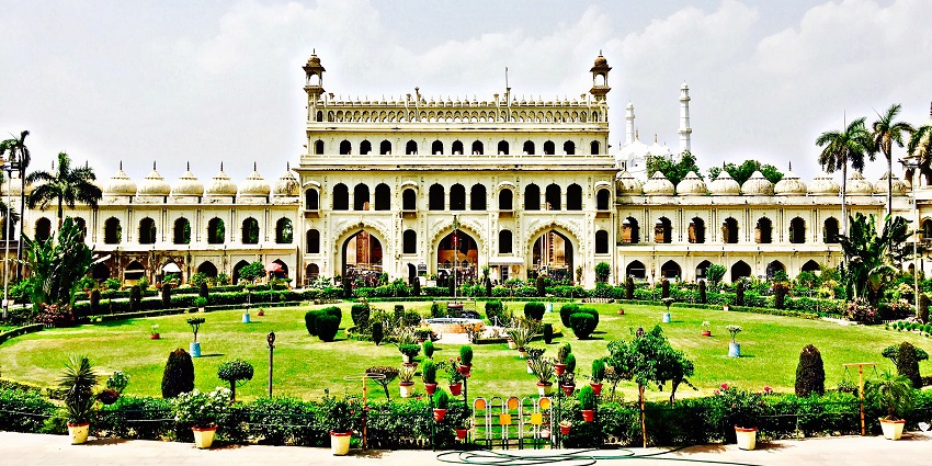 A picture of the Bara Imambara depicting the architecture and the gardens with greenery.