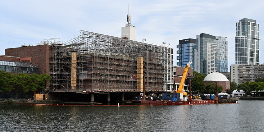 A wide view of the Museum of Science with a bridge in the background in Boston, MA.