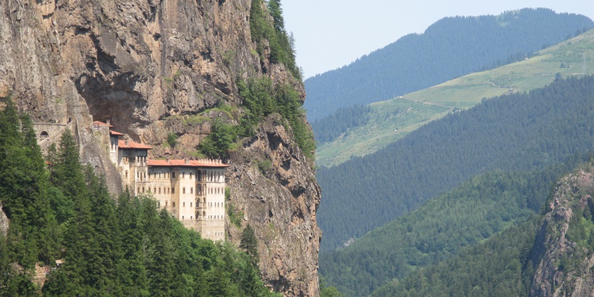 Sumela Monastery perched on steep cliff in Trabzon, Turkey, viewed from winding roadside