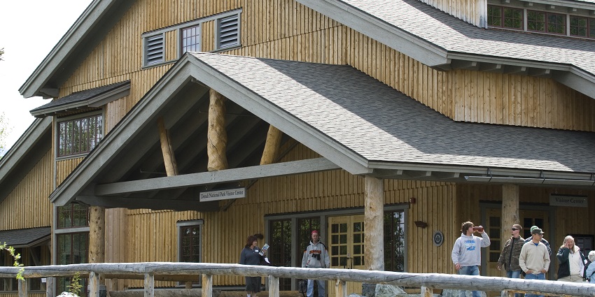 The Denali Visitor Center with rustic architecture, mountain views, and lush forest surroundings.