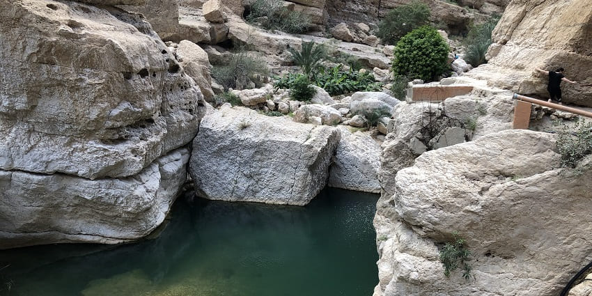 Scenic valley with emerald pools, waterfalls, and rocky terrain
