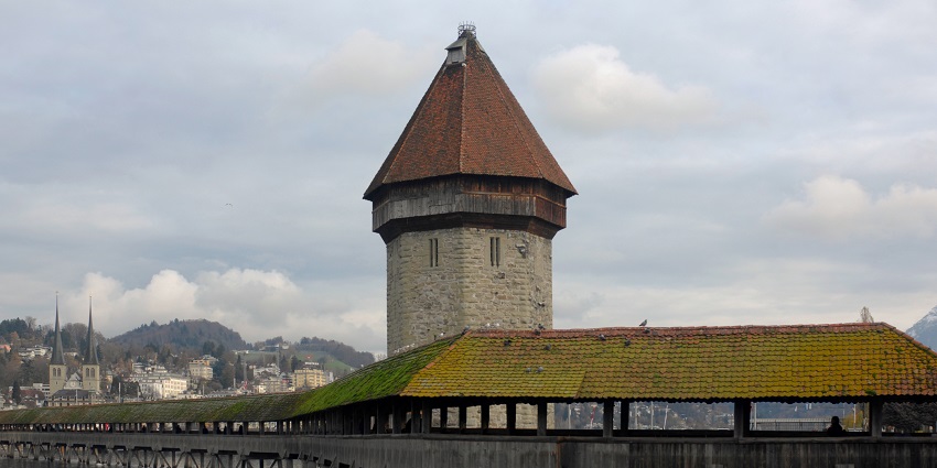 Historic wooden bridge with paintings and scenic views of Lucerne.