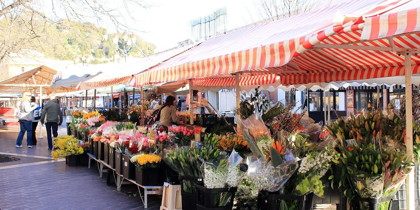 Bustling market with flowers, fresh produce, and local delicacies.