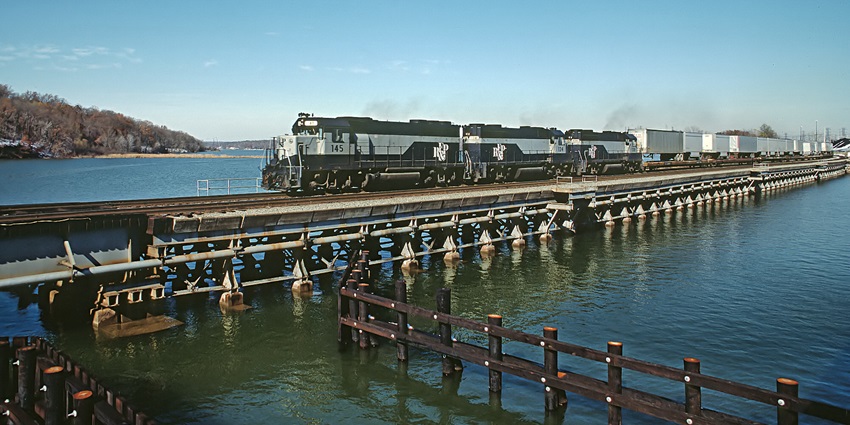 A picture of a railway bridge over a water body in Fredericksburg with a train crossing it