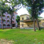 An image of a serene building in Durgapur with green landscape in the backdrop.