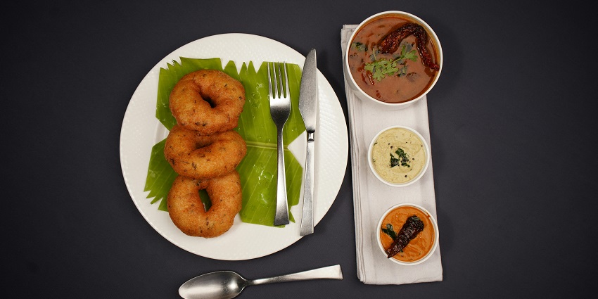 A plate of medu vada served with chutney and sambar at a restaurant near Vakrakaliamman Temple.
