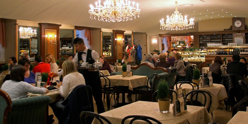 A view of a stylish restaurant with elegant tables, ambient lighting, and a lively atmosphere.