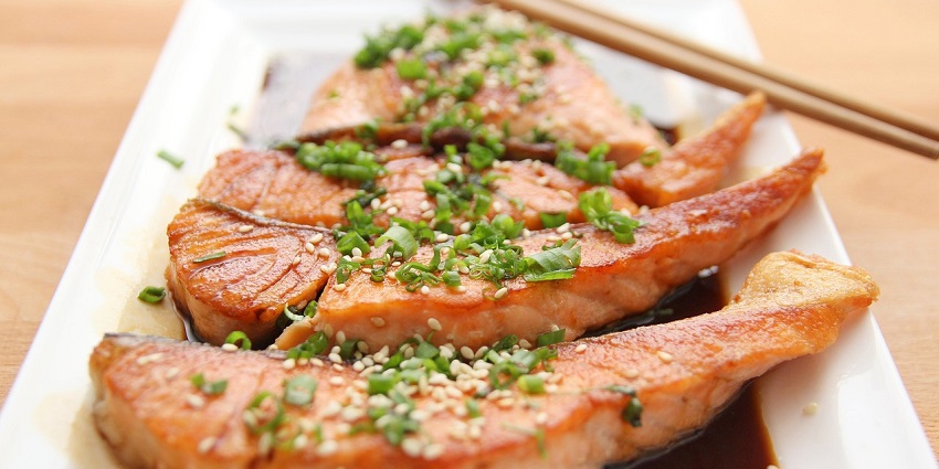 An image of a delicious plate of teriyaki salmon with garnishes, served as a gourmet meal.