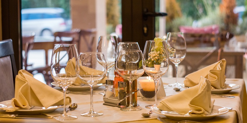 Sophisticated restaurant table setting with elegant tableware and folded napkins.